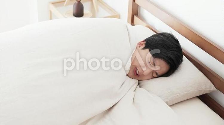 ベッドの中で寒気を感じる男性 男性,寒気,冷えの写真素材