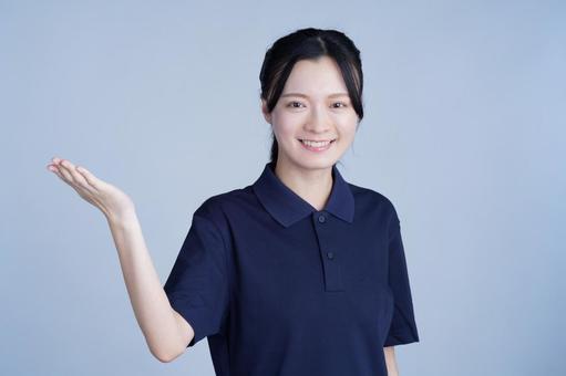 紺色の服の女性が片手を横に出す 女性,案内,紹介の写真素材