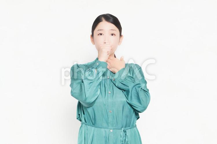 白背景の前に立って喉に手を当てる主婦 喉,咳,主婦の写真素材