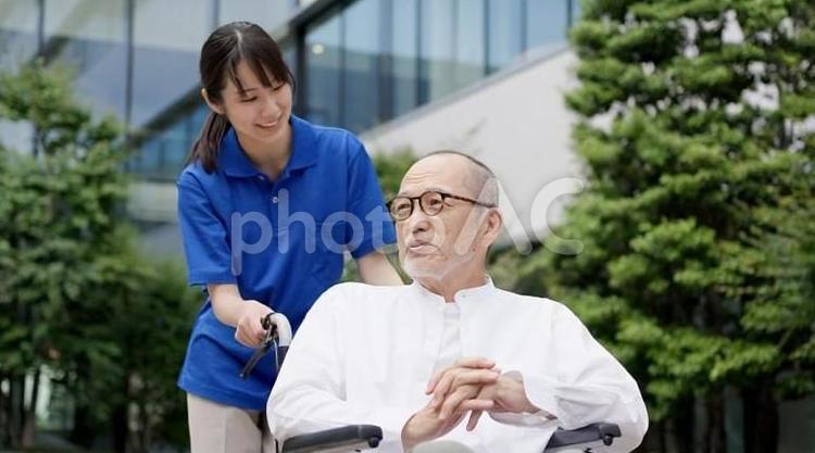 散歩をする車椅子の高齢者と介護士 高齢者,介護士,散歩の写真素材