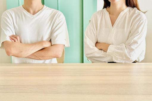 テーブルに横並びに座る若い男女 テーブルに横並びに座る若い男女の写真