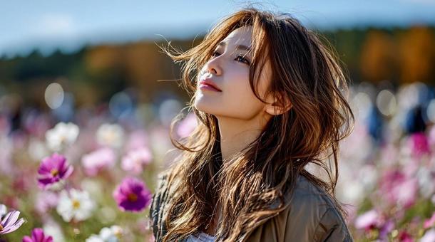 コスモス畑で微笑む女性の秋ポートレートの写真