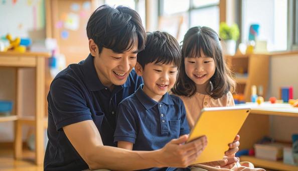 タブレットで遊ぶ保育士と子ども タブレットで遊ぶ保育士と子どもの写真