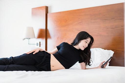 ベッドで電子書籍を読む若い女性 ベッドで電子書籍を読む若い女性 電子書籍,sns,視聴者の写真素材