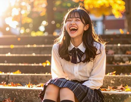 秋のキャンパスで笑顔を見せる女子学生 秋のキャンパスで笑顔を見せる女子学生の写真