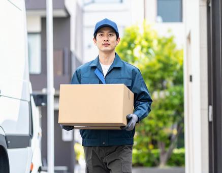 宅配ドライバーとして頑張る男性の配達風景の写真