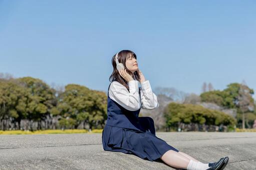青空の下で音楽を楽しむ女子高校生 女子高校生,高校生,学生の写真素材