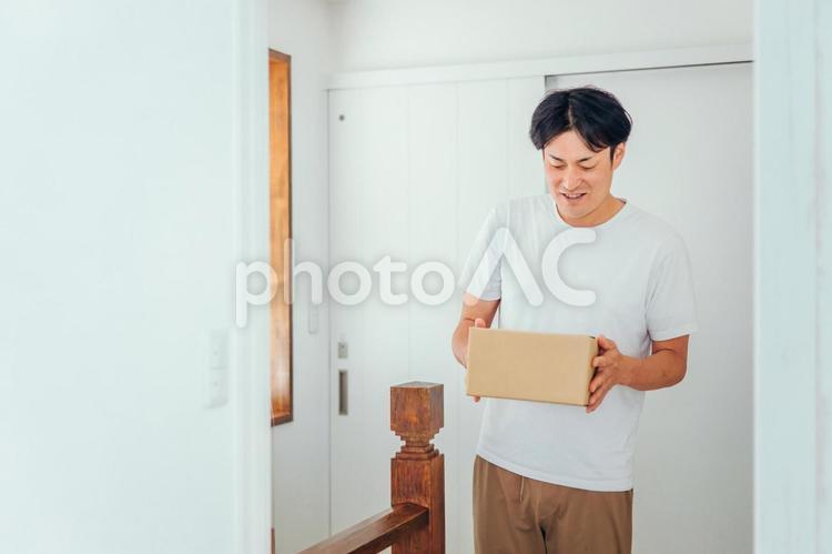 段ボールを運ぶ男性（笑顔） 通販,ネットショッピング,ダンボールの写真素材