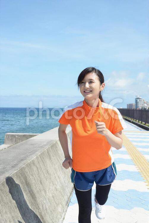 海岸でジョギングを楽しむ女性 沖縄,女性,女の写真素材