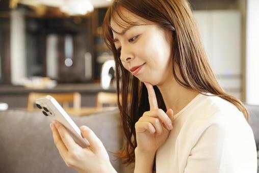 A young woman relaxing and enjoying her smartphone, JPG