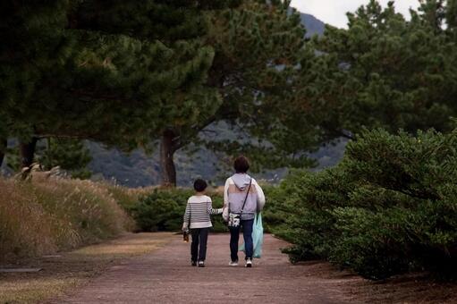 ＜素材＞夕暮れの公園の遊歩道を歩く親子 家族,親子,ウォーキングの写真素材