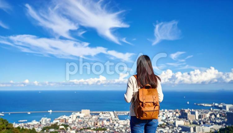 青空の下、遠くの景色を眺める女性の後ろ姿 女性,後ろ姿,青空の写真素材