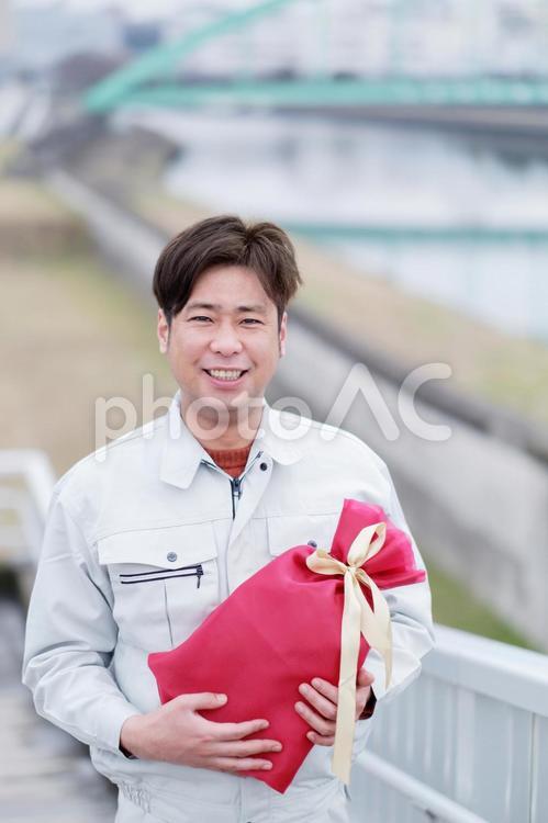 プレゼントを持つ作業員1 配達員,宅配業者,男性の写真素材