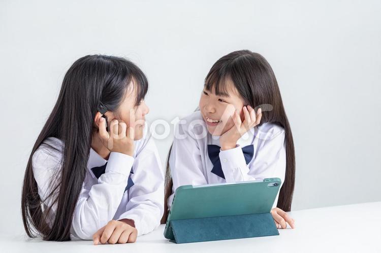 イヤホンをしてタブレットを見る学生 子ども,イヤホン,制服の写真素材
