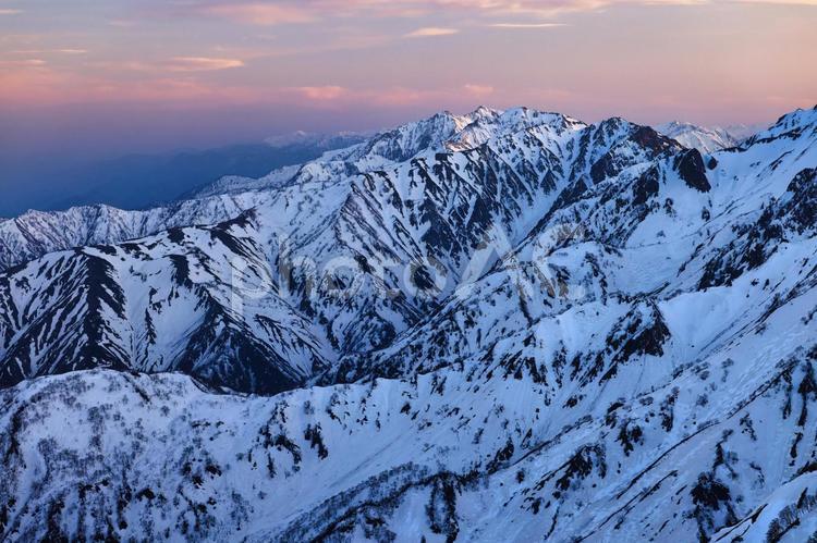 夕焼けの冠雪の北アルプスの後立山連峰 夕焼け,アーベントロート,冠雪の写真素材