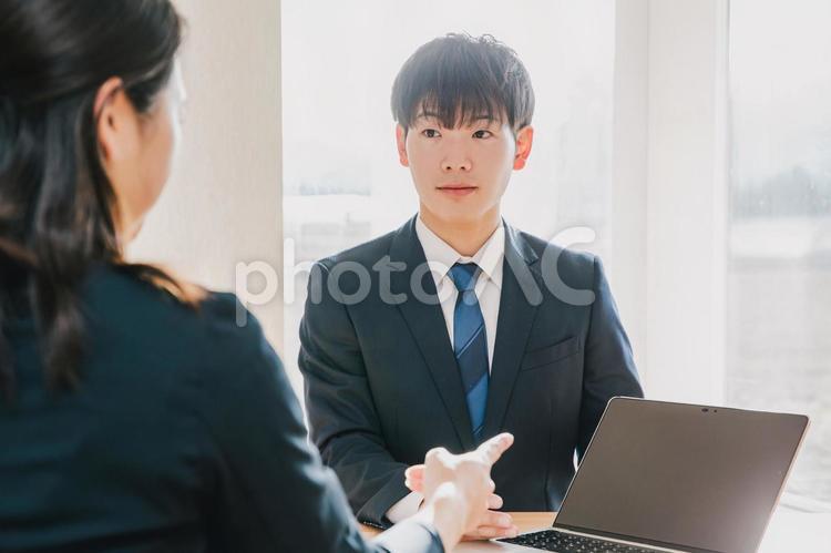 スーツを着た男性がPCを使って仕事をする ビジネスシーン,ビジネス,営業マンの写真素材