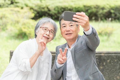 スマホで写真や動画を撮る高齢者夫婦 高齢者,旅行,スマホの写真素材