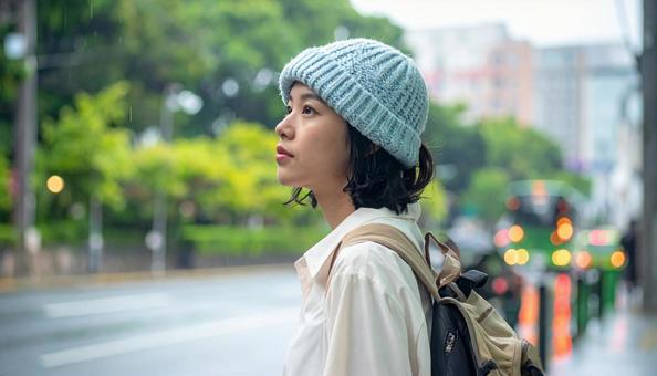 雨の中バス停でバスを待つ日本人女性 雨の中バス停でバスを待つ日本人女性の写真