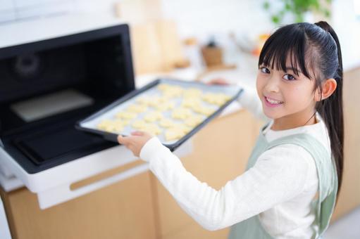 焼く前のクッキーを持って笑顔を見せる女の子 女の子,日本人,クッキーの写真素材
