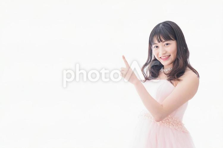 ポイントを指差す若い花嫁 ハンドサイン,本番,ウェディングドレスの写真素材