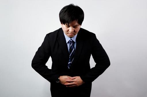 腹痛でお辞儀する男性 腹痛でお辞儀する男性 腹痛,男性,スーツの写真素材