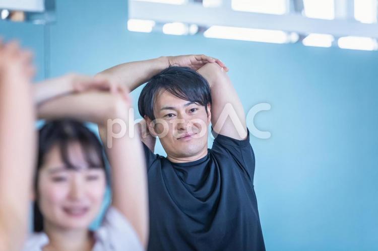 スポーツジムでスタジオメニューをする男女 ストレッチ,運動,準備運動の写真素材
