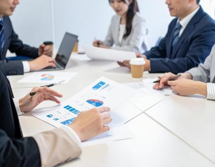 オフィスで打合せする4人の男女 オフィスで打合せする4人の男女の写真