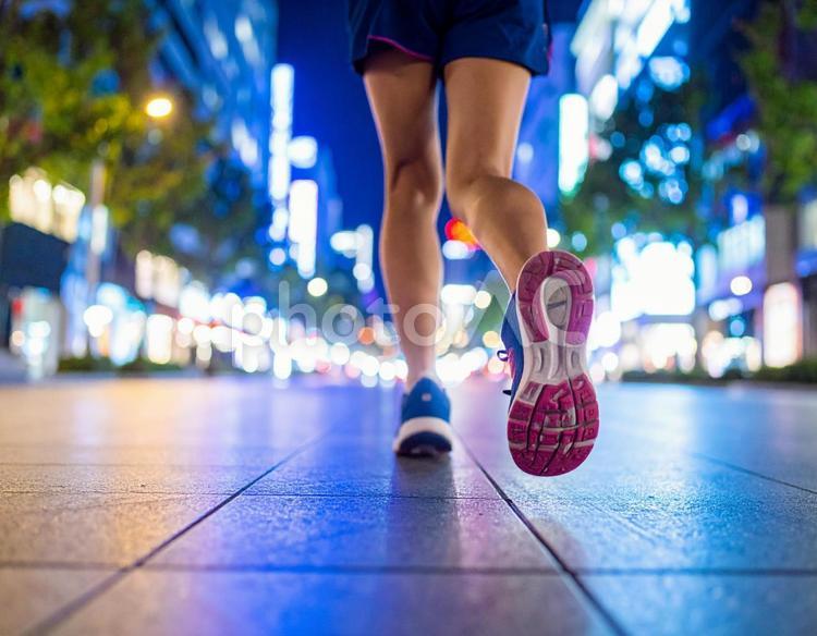 夏の夜のネオン街をランニングする女性 ランニング,ジョギング,フィットネスの写真素材