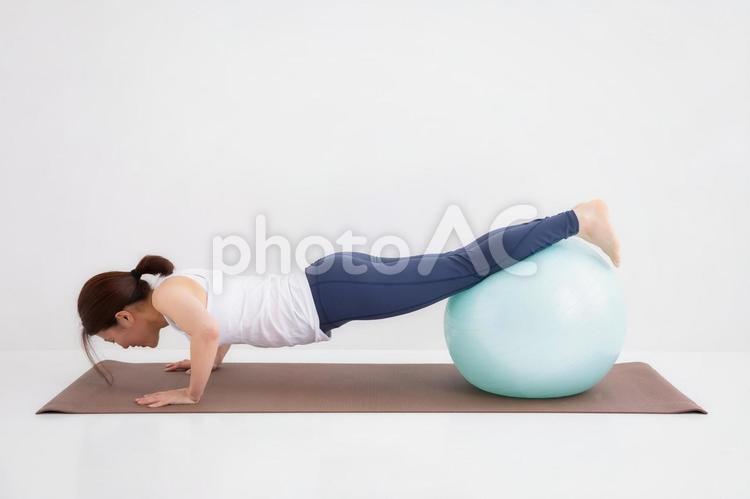 スポーツウェアを着た女性 腕立て伏せ,バランスボール,腕立ての写真素材