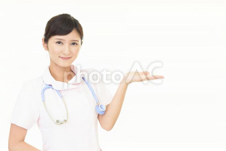 掌を見せる笑顔の看護師 女性,女,看護師の写真素材