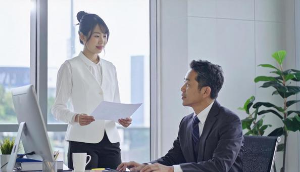 上司に報告する女性社員 上司に報告する女性社員の写真