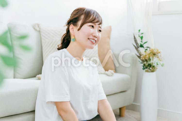 ソファの前で座るリラックスした日本人女性 女性,笑顔,リラックスの写真素材