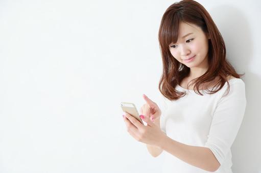 スマートフォンを使う女性 スマートフォンを使う女性 スマートフォン,カジュアル,検索の写真素材