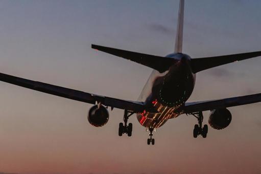 夕暮れの空に着陸する旅客機 夕暮れの空に着陸する旅客機の写真