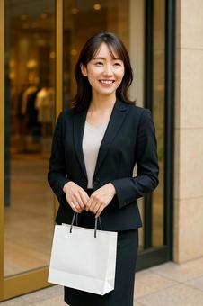 ブティック前で紙袋を持つ女性 ブティック前で紙袋を持つ女性の写真