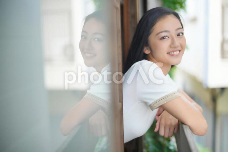 窓から顔を出しカメラ目線の女性 女性,日本人,窓際の写真素材