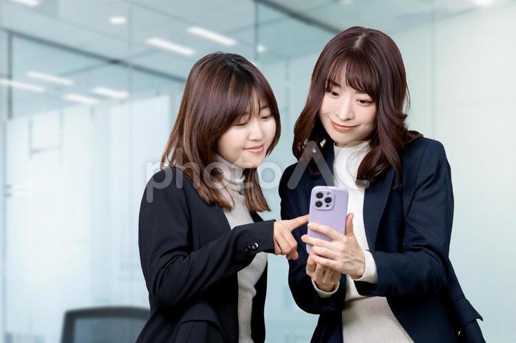 スマホを見て話す2人のビジネスウーマン 女性,ビジネス,笑顔の写真素材