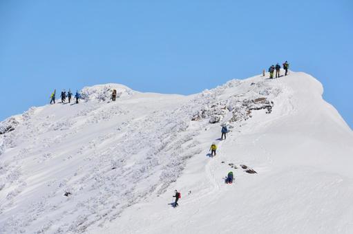 雪の谷川岳山頂（オキの耳）と登山者 雪山,冬山,谷川岳の写真素材
