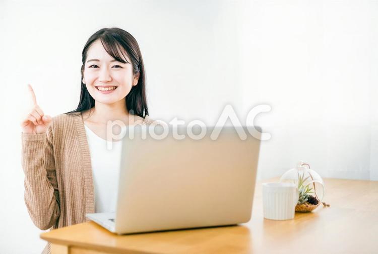 家でノートパソコンを使う女性（笑顔） パソコン,在宅ワーク,ポイントの写真素材