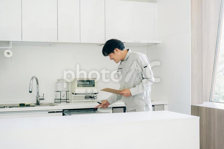 キッチンと作業着姿の男性（食洗機） 食洗機,食器洗い乾燥機,作業服の写真素材