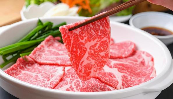焼肉用の生肉を箸でつまむ 焼肉用の生肉を箸でつまむの写真