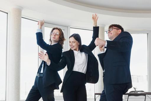 楽しそうに踊るスーツの3人 男女,外国人,ビジネスの写真素材