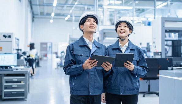 工場でタブレットで製品を検査する作業員 工場でタブレットで製品を検査する作業員の写真