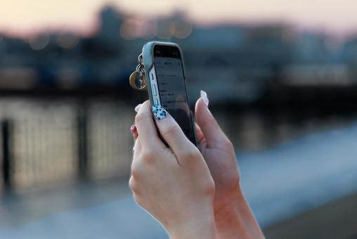 夕暮れのネイルとスマホ 夕暮れのネイルとスマホの写真