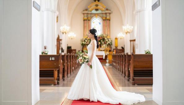 教会のバージンロードを歩く花嫁の横姿 教会のバージンロードを歩く花嫁の横姿の写真