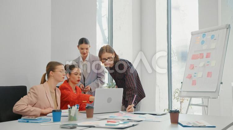会議室でノートパソコンを見ている4人の男女 ビジネス,ビジネスマン,ビジネスウーマンの写真素材
