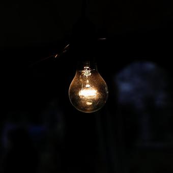 暖色カラーに光る裸電球の写真