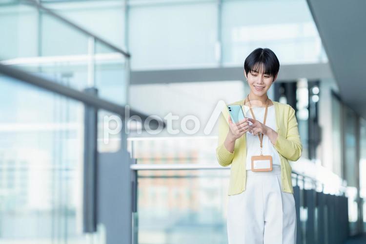 オフィスでスマホを見る女性エンジニア ビジネス,エンジニア,ビジネスマンの写真素材
