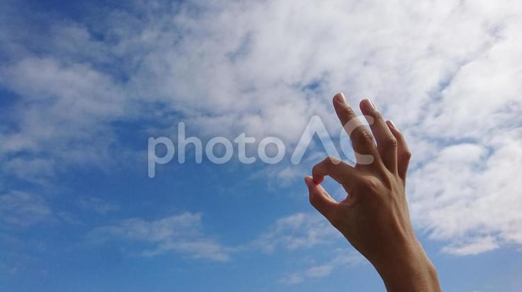 青空と白い雲にOKの指サイン いいよ,了解,許可の写真素材