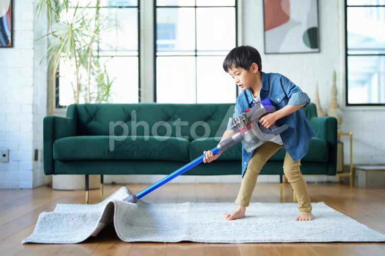 掃除する男の子が絨毯を吸い込む様子 男の子,小学生,リビングの写真素材